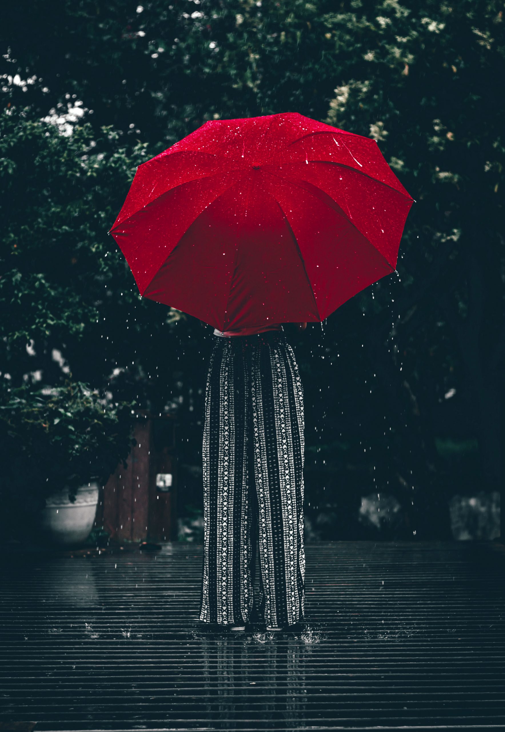 A woman holding a red umbrella.